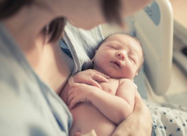 Yeni doğan erkek bebek annesinin kollarında dinleniyor..