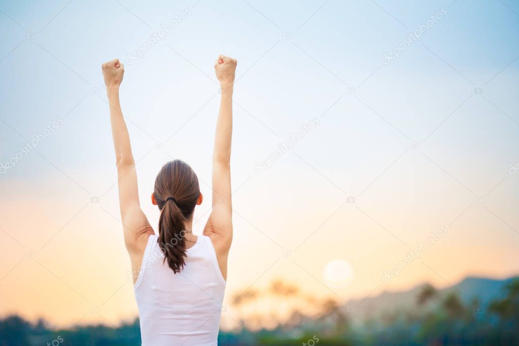 Strong and confident woman with arms in the air. 