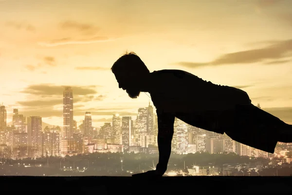 Silhouette of man doing push up exercise, early morning exercise workout, motivational image.