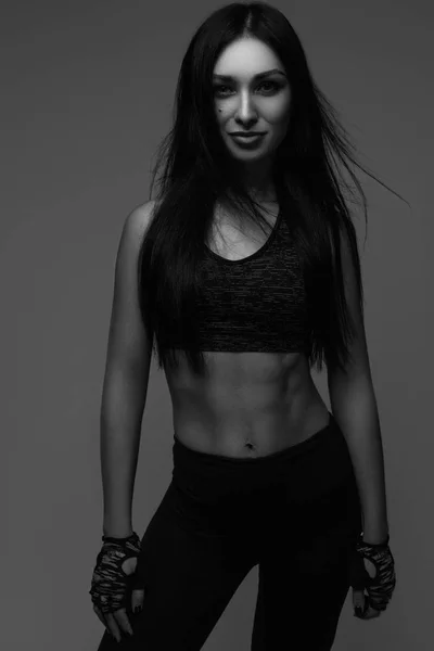 Sports girl posing. Fitness model woman in studio.