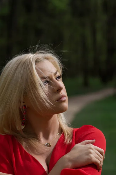 Kırmızı Elbiseli Parkta Ararken Düşünceli Sarışın Kadın — Stok fotoğraf