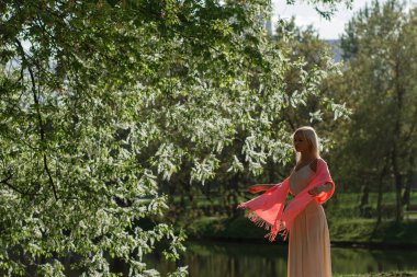 Uzun kırmızı elbiseli güzel ve zarif kız Ortaçağ Kalesi ortasında duruyor