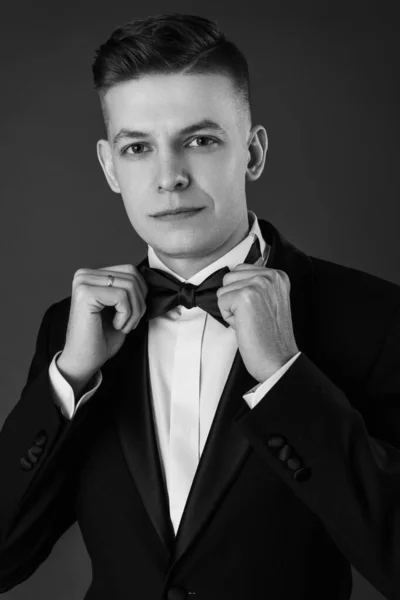 黒の背景にスーツとネクタイを身に着けている魅力的な若いビジネスマンの肖像画 クラシックスタイル スタジオショット — ストック写真