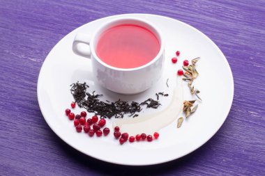 Bir fincan sağlıklı geleneksel bitkisel robolar ahşap masada kırmızı içecek çayı.