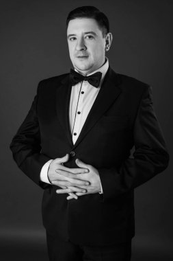 Takım elbiseli gülümseyen adamın stüdyo portresi