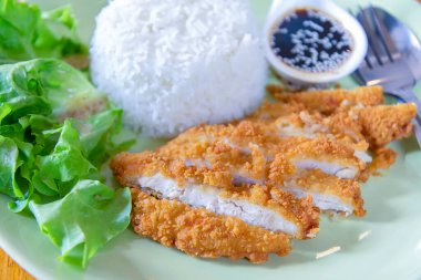 Yeşil tabakta gevrek domuz etli pilav.