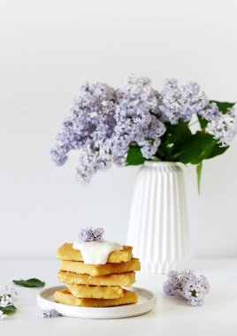 Fincan kapuçino, Belçika Waffle ile plaka, sabah kavramı menekşe leylak çiçekli Beyaz vazo