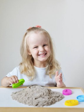 Eve erken eğitim okul geliştirme çocuk oyunu için hazırlanıyor kinetik kumla oynayan küçük beyaz kız