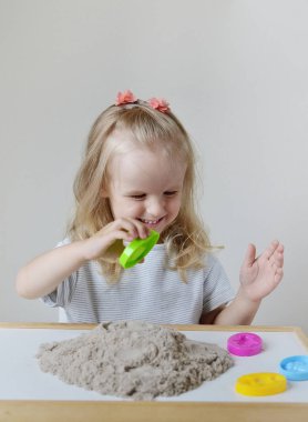 Eve erken eğitim okul geliştirme çocuk oyunu için hazırlanıyor kinetik kumla oynayan küçük beyaz kız