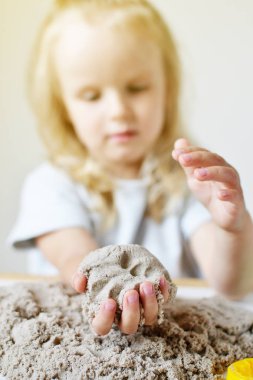 Eve erken eğitim okul geliştirme çocuk oyunu için hazırlanıyor kinetik kumla oynayan küçük beyaz kız