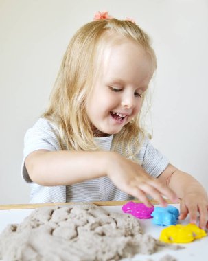 Eve erken eğitim okul geliştirme çocuk oyunu için hazırlanıyor kinetik kumla oynayan küçük beyaz kız