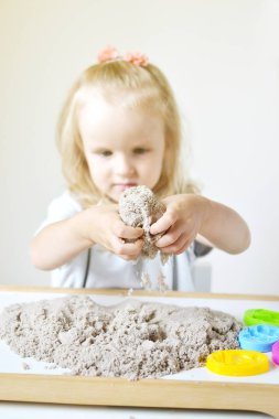 Eve erken eğitim okul geliştirme çocuk oyunu için hazırlanıyor kinetik kumla oynayan küçük beyaz kız