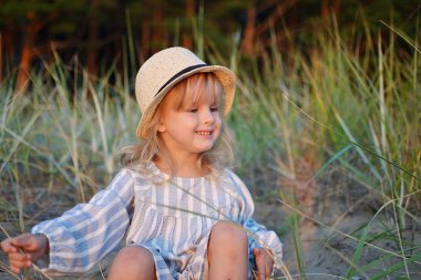 Küçük beyaz kız elbise ve şapka yürüyüş plaj açık, yaz saati, güneş ışığı, mutlu duygular, Özgürlük kavramı