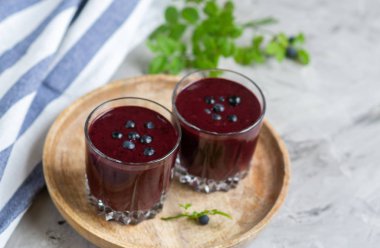 Lezzetli vahşi blueberry smoothie süt yoğurt dondurma gri arka plan yaz içki kavramı