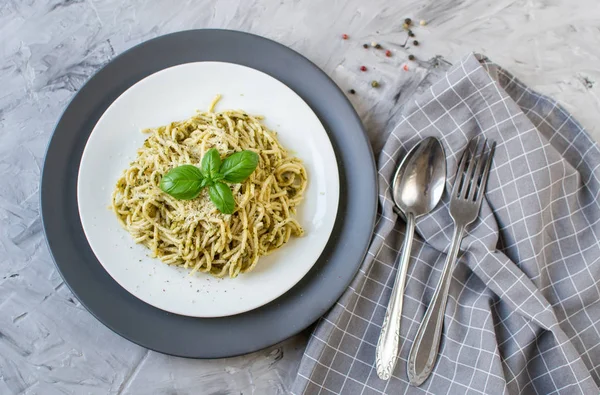 Cooked spaghetti pasta on a plate with basil pesto and Parmesan cheese, Italy food, healthy concept, vegetarian