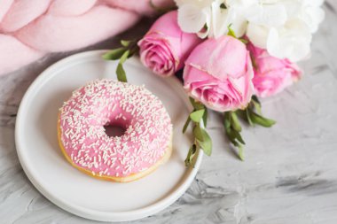 Fincan kapuçino, halka, pembe pastel dev battaniye, çiçekler, yatak odası, sabah kavramı ile