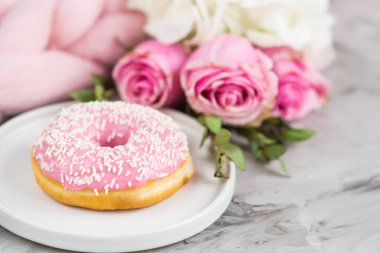 Fincan kapuçino, halka, pembe pastel dev battaniye, çiçekler, yatak odası, sabah kavramı ile