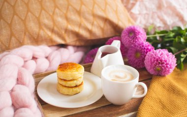 Beyaz fincan kahve Cappuccino süzme peynir krep, sarı hardal rengi ekose, yatak odası, sonbahar kavramı, rahatlık