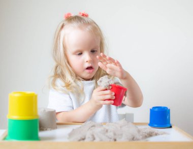 Eve erken eğitim okul geliştirme çocuk oyunu için hazırlanıyor kinetik kumla oynayan küçük beyaz kız