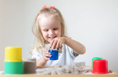 Eve erken eğitim okul geliştirme çocuk oyunu için hazırlanıyor kinetik kumla oynayan küçük beyaz kız