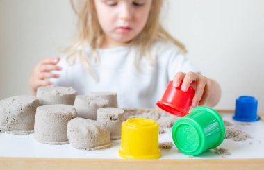 Eve erken eğitim okul geliştirme çocuk oyunu için hazırlanıyor kinetik kumla oynayan küçük beyaz kız