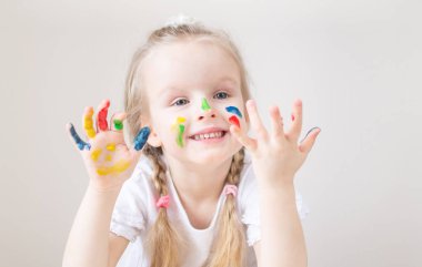 Eve erken eğitim okul okul öncesi geliştirme çocuk oyunu için hazırlanıyor, beyaz küçük kız boyama renkli elleri ile boyar