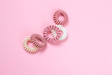 Saç sarmal scrunchies pembe arka plan, güzellik kavramı, üzerinde yatıyordu düz