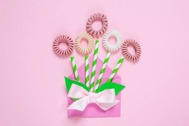 Saç sarmal scrunchies pembe bir arka plan, yaratıcı bahar kavramı, düz lay, kadının gün çiçek