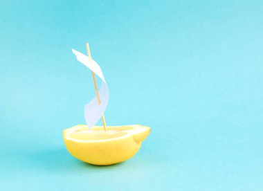 Yaz seyahat kavramı, yarım limon beyaz yelken, koyun, açık mavi renkli, düz lay, minimalizm ile