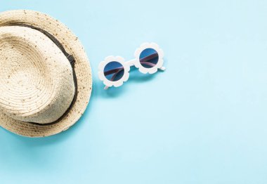 Mavi arka planda beyaz modern güneş gözlüğü, tropikal yaprakları bileşimi. Plaj rahatla. Yaz yaratıcı kavramı. Düz Lay. Üst görünüm