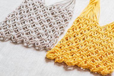 Keten arka plan üzerinde el yapımı macrame alışveriş çantaları, Çevre dostu. Nakış. Modern yaz konsepti