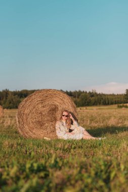 Samanlıklarla tarlada yürüyen kadın, yaz saati, kırsal