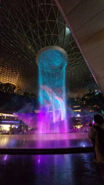 SINGAPORE - 18 May, 2025: Night view of parallax view of indoor Singapore rain vortex dome waterfall.