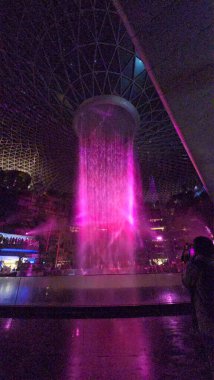 SINGAPORE - 18 May, 2025: Night view of parallax view of indoor Singapore rain vortex dome waterfall.