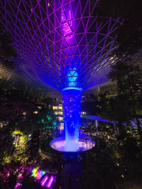 SINGAPORE - 18 May, 2025: Night view of parallax view of indoor Singapore rain vortex dome waterfall.