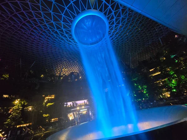 SINGAPORE - 18 May, 2025: Night view of parallax view of indoor Singapore rain vortex dome waterfall.