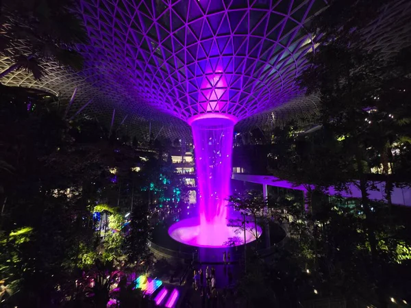 SINGAPORE - 18 May, 2025: Night view of parallax view of indoor Singapore rain vortex dome waterfall.
