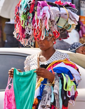 Accra, Gana / 1,2018 olabilir: bir kadın t-shirt piyasada satmaktadır. Onun mallar kafasına takıyor