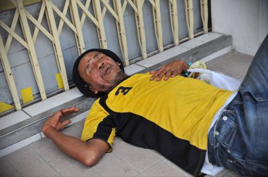 Bangkok, Tayland - 18 Şubat 2012: Kimliği belirsiz uyumayan şehir merkezi dükkan kapı aralığında