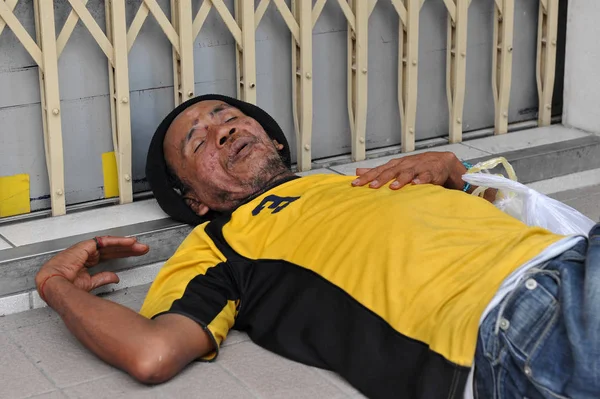 BANGKOK, THAILAND - Feb 18, 2012: Unidentified man sleeps in a city centre shop doorway
