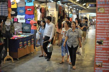 Hua Hin, Thailand - October 26, 2012: Shoppers walk through a busy night market on a town center street. The seaside town of Hua Hin is a popular travel destination for Thais and foreign tourists.