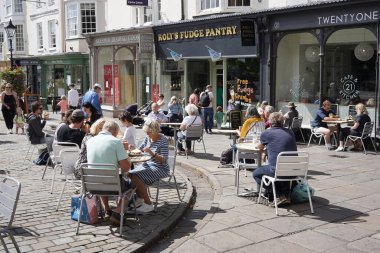 Wells, UK - August 20, 2020: People dine out at street-side restaurants. The Government-backed Eat Out To Help Out Scheme has boosted the hospitality industry in the wake of the Covid-19 pandemic. clipart