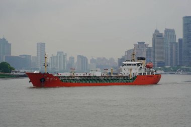 29 Nisan 2019 'da Şangay' ın Pudong bölgesinde Huangpu Nehri 'ndeki bir kargo gemisi Şangay, Çin' de sisli bir günde gökdelenlerden geçer..