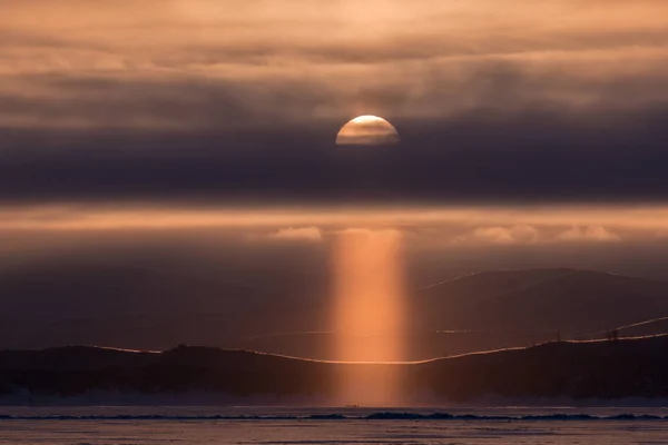 Sun pillar at dawn on Lake Baikal