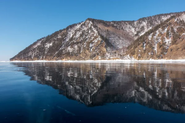 Reflejo de las orillas del lago Baikal en el hielo transparente —  Fotos de Stock