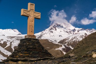 Trinity Kilisesi yakınlarındaki Kazbek Dağı'nın arka planında kutsal haç