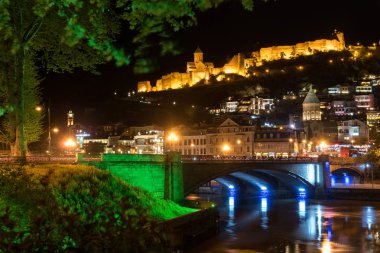 Tiflis'teki Metekhi Köprüsü ve Narikala Kalesi'nin gece manzarası