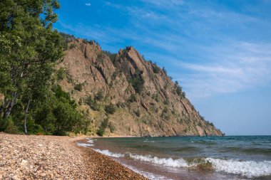 Skriper cliff - a large rock on the shore of Lake Baikal near the village of Big Koty clipart