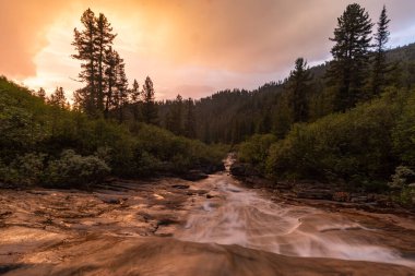 Gün batımında Khamar-Daban dağlarındaki Podkomarnaya nehrinde şelale.
