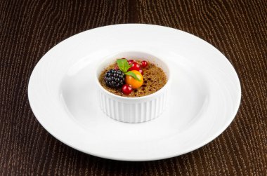 Creme brulee kırmızı kuş üzümü, böğürtlen, nane ve karanlık bir arka plan üzerinde kış kiraz